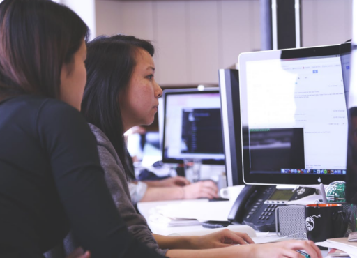An image of two women looking at a computer screen, representative of reviewing a first hotline report.