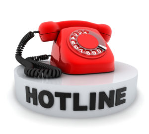 A red phone sitting on an object that says hotline. All implying a hotline service.
